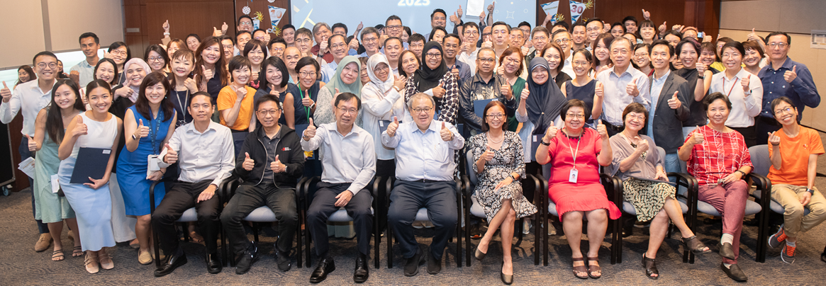 Audience in business casual attire in an auditorium.
